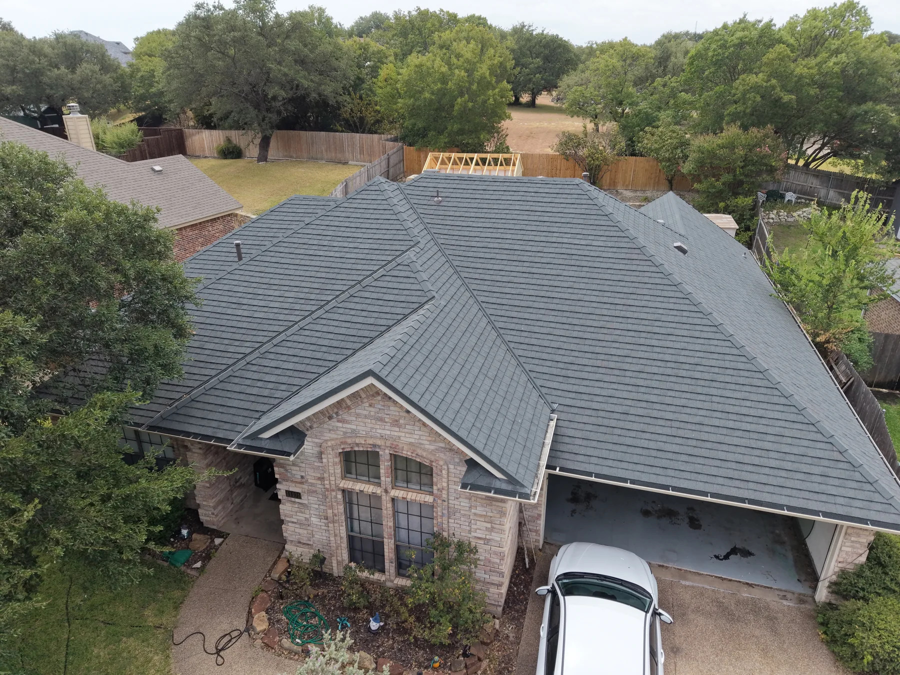 Slate Stormetal Shingle roof above the brick gable of a residential home
